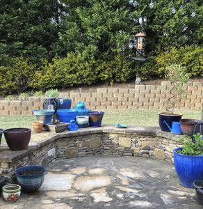 Several plant pots on a stone patio.