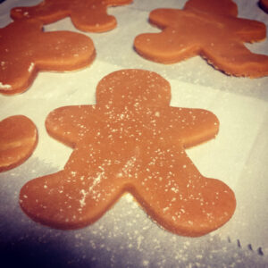 An uncooked gingerbread man on a baking sheet. 