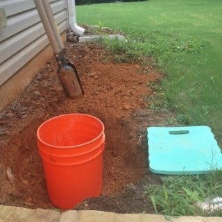 photo of yard where grass dug up and hole in the ground with bucket3
