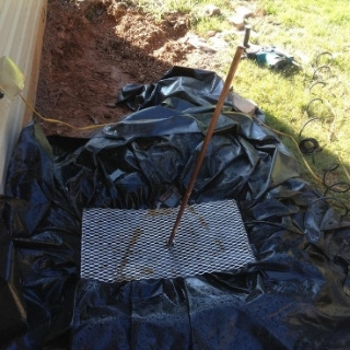 photo of yard where grass dug up and heavy duty plastic placed to prep for water fountain diy 3